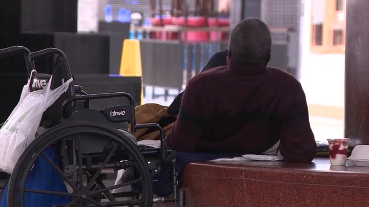 Person rests on bench at Atlanta airport