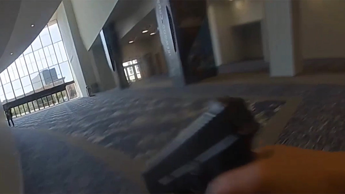A officer holds a gun inside Lakewood Church