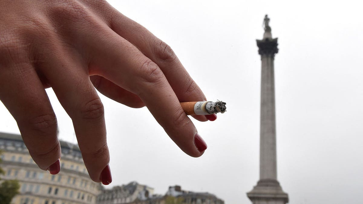 A woman holds a cigarette