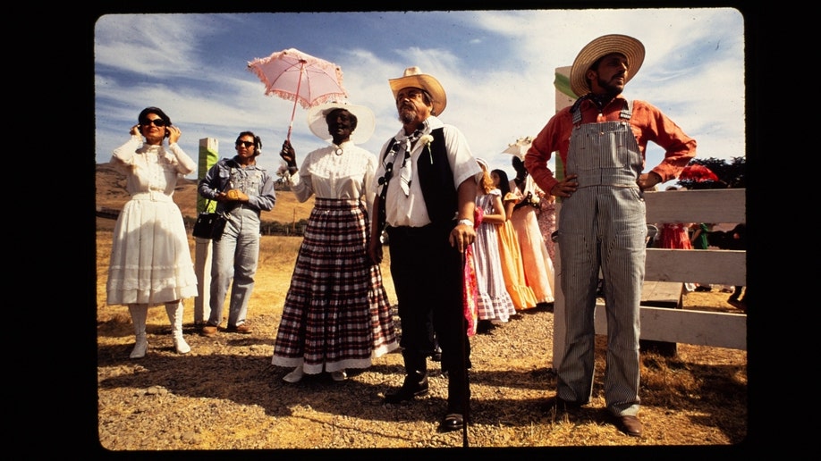 Chuck Diederich and his wife wearing costumes lead a group of other Synanon members
