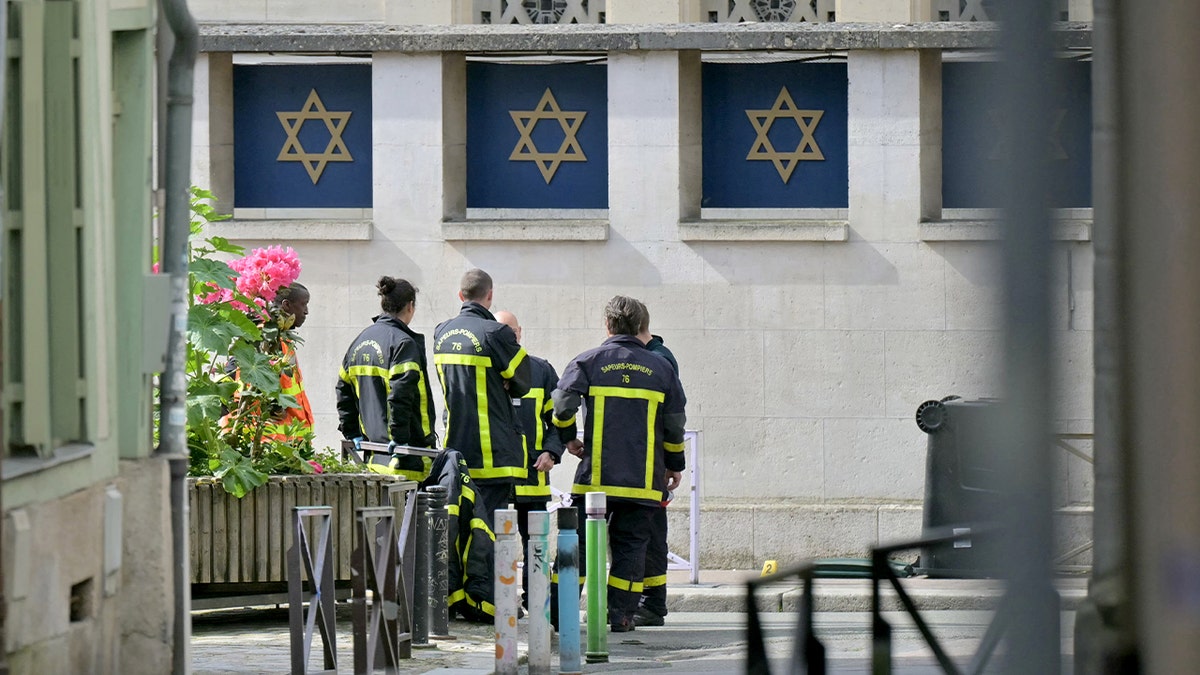 Firefighters stand outside French synagogue