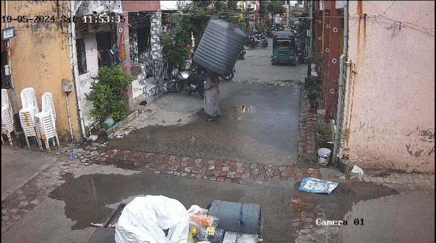 Woman escapes injury after water tank falls from building, lands perfectly around her