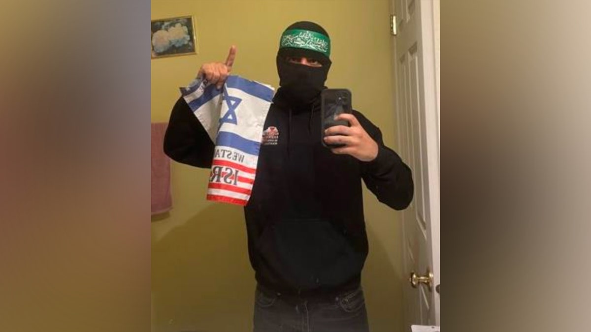 Man in Hamas-style headband holding Israeli flag in a selfie