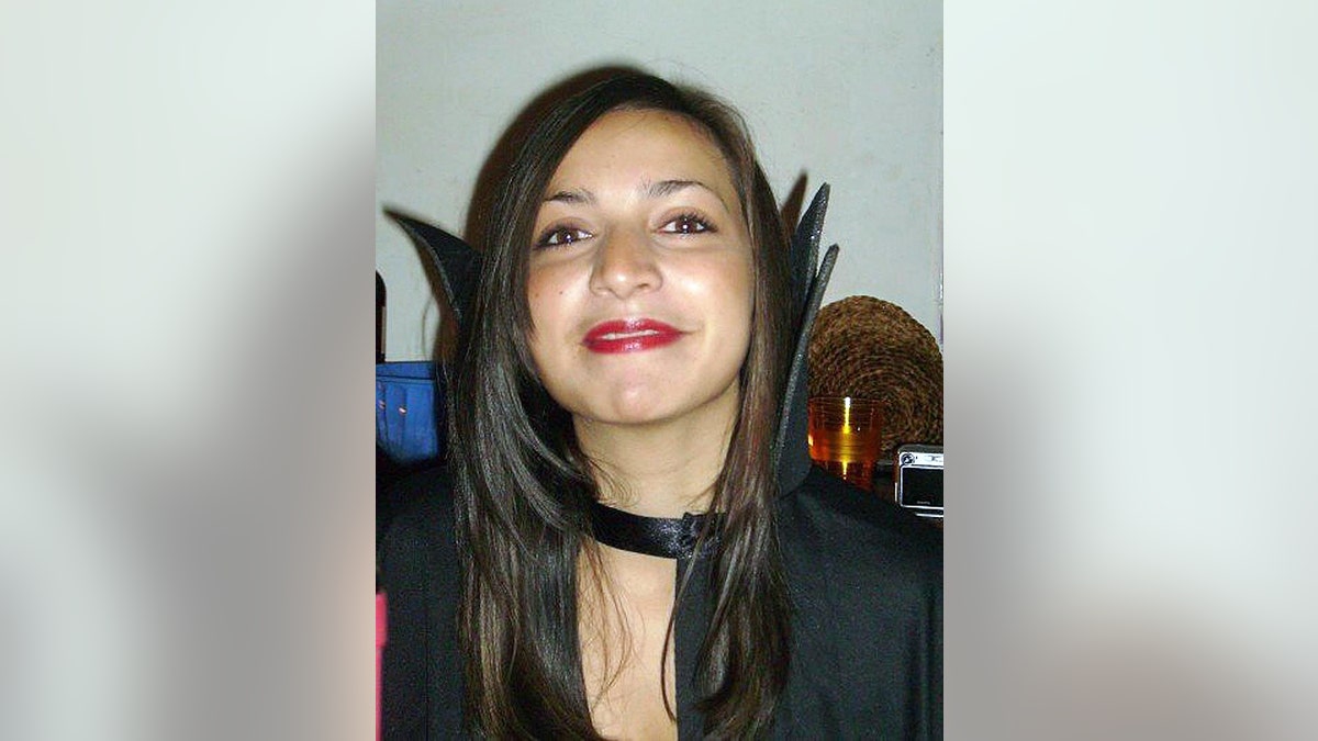 A close-up of Meredith Kercher smiling and wearing a black dress.