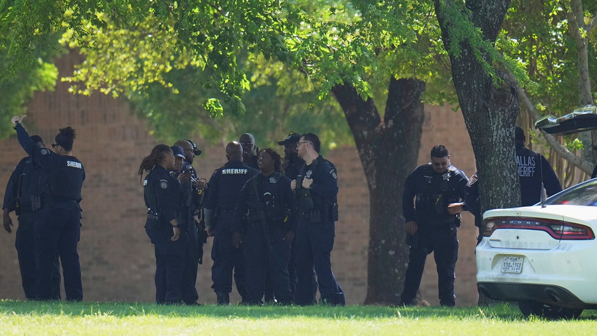 A group of police officers standing around near Wilmer-Hutchins High School