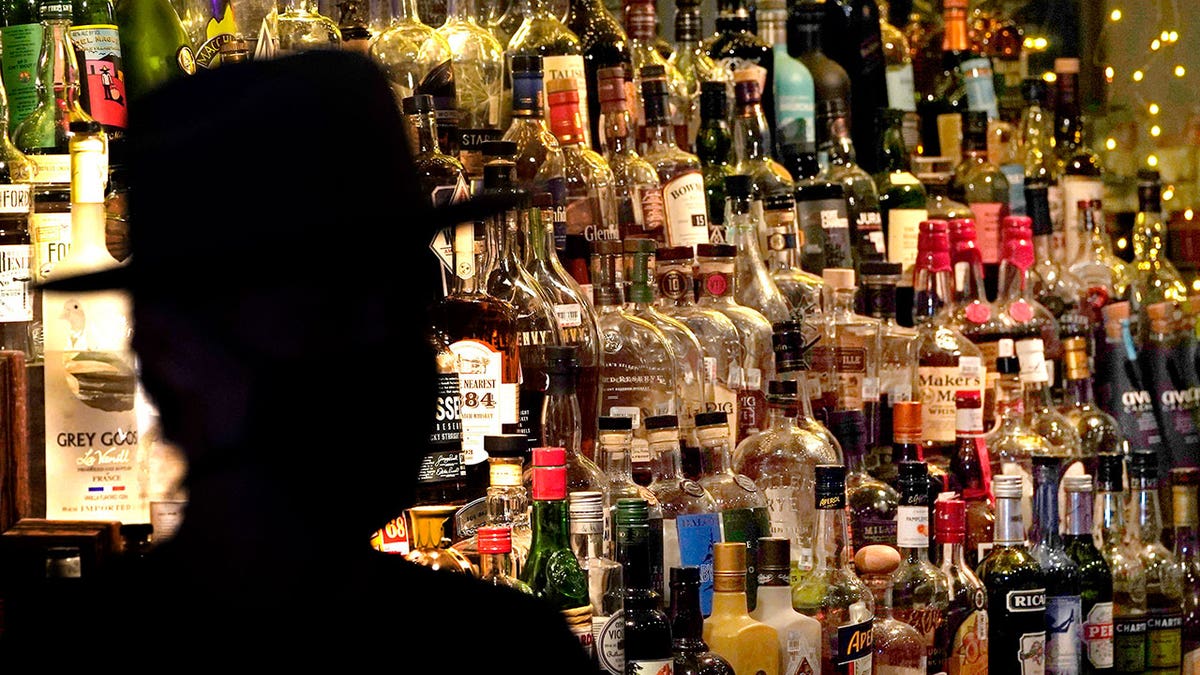 bottles of alcoholic beverages on shelves at bar