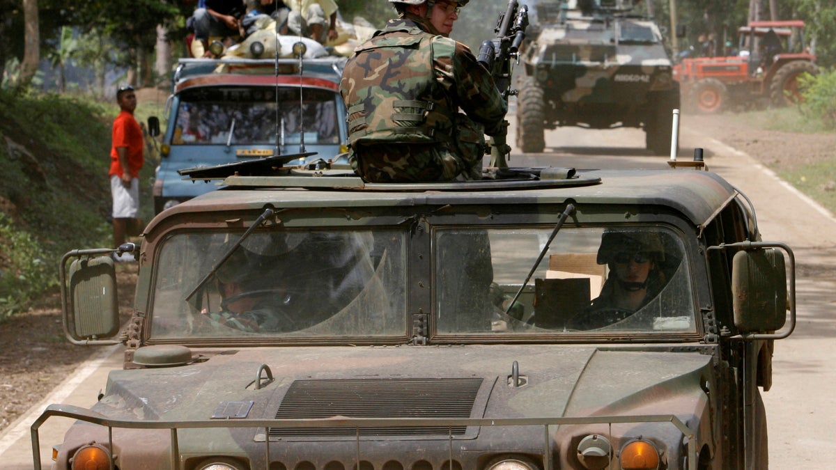 U.S. army soldiers onboard a humvee are escorted by a Philippine government armoured vehicle while patrolling Maimbung town in Jolo province, southern Philippines January 25, 2007