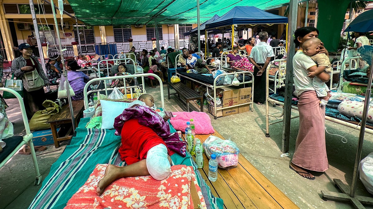 People lie on beds near Burma hospital