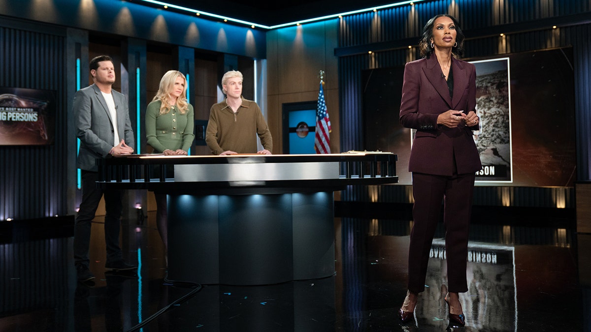 Harris Faulkner speaking in front of a group of panelists for "America's Most Wanted: Missing Persons"