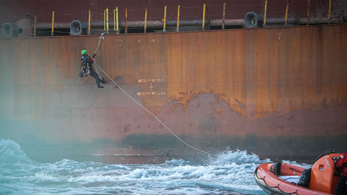 An activist of the environmental NGO Greenpeace climbs to take part in an action on a Shell platform, on the way to the North Sea, to expand an existing oil and gas field, off the coast of Cherbourg, northwestern France, on Feb. 6, 2023.