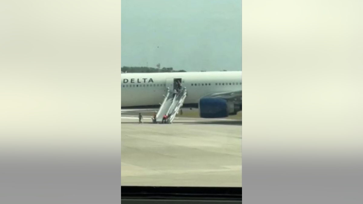 passengers using emergency slide to exit plane on tarmac