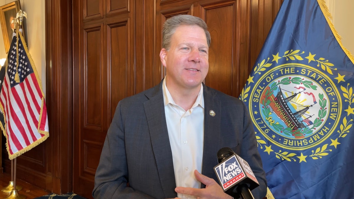then-Gov. Chris Sununu between US, NH flags