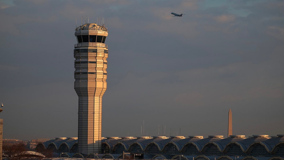 A plane is seen flying near the air traffic control tower at DCA
