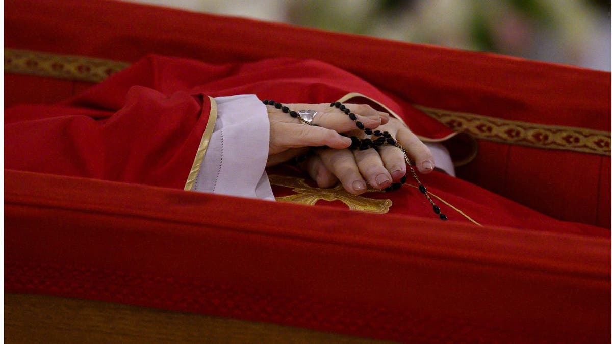 Close-up of the hands of Pope Francis as his body lays in state in a coffin in the Vatican
