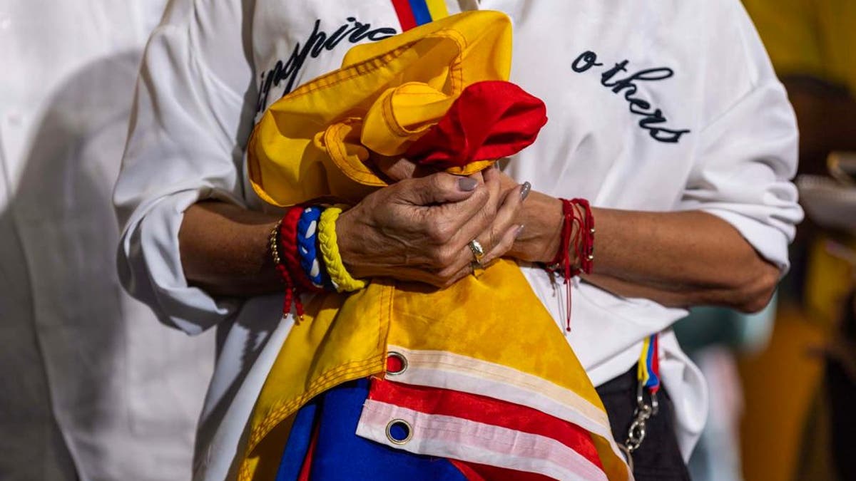 hands clutching Venezuelan flag