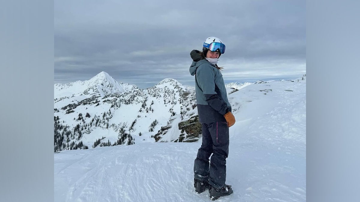 Ellery Curtis wearing a ski suit and overlooking a snowy mountain