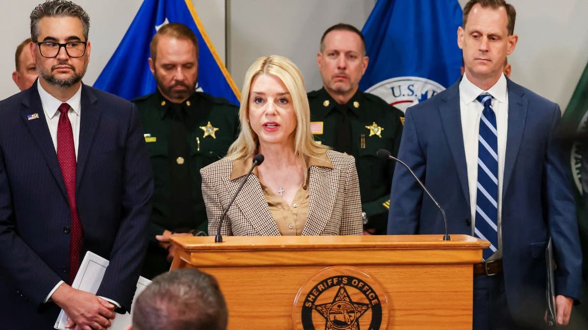 Pam Bondi with law enforcement officials at podium