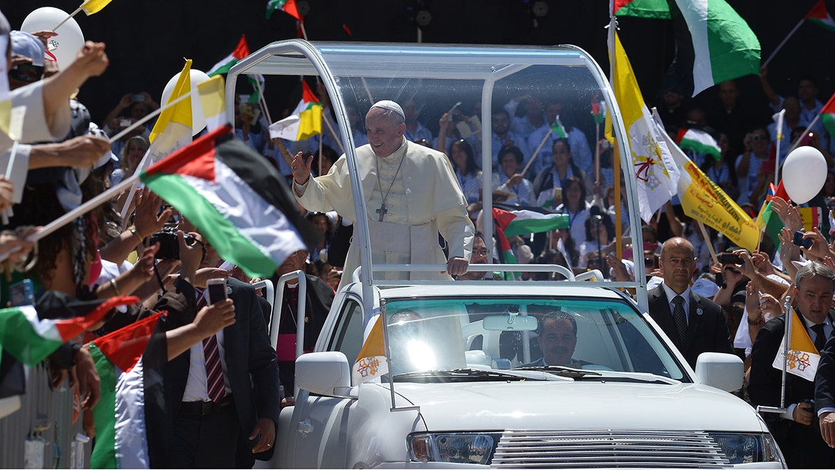 Crowd waves Palestinian flags greeting Pope Francis in popemobile