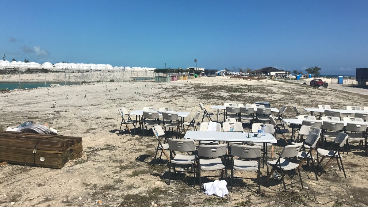 Rows of white tents on a beach in the Bahamas and plastic dining tables at Fyre Festival in 2017