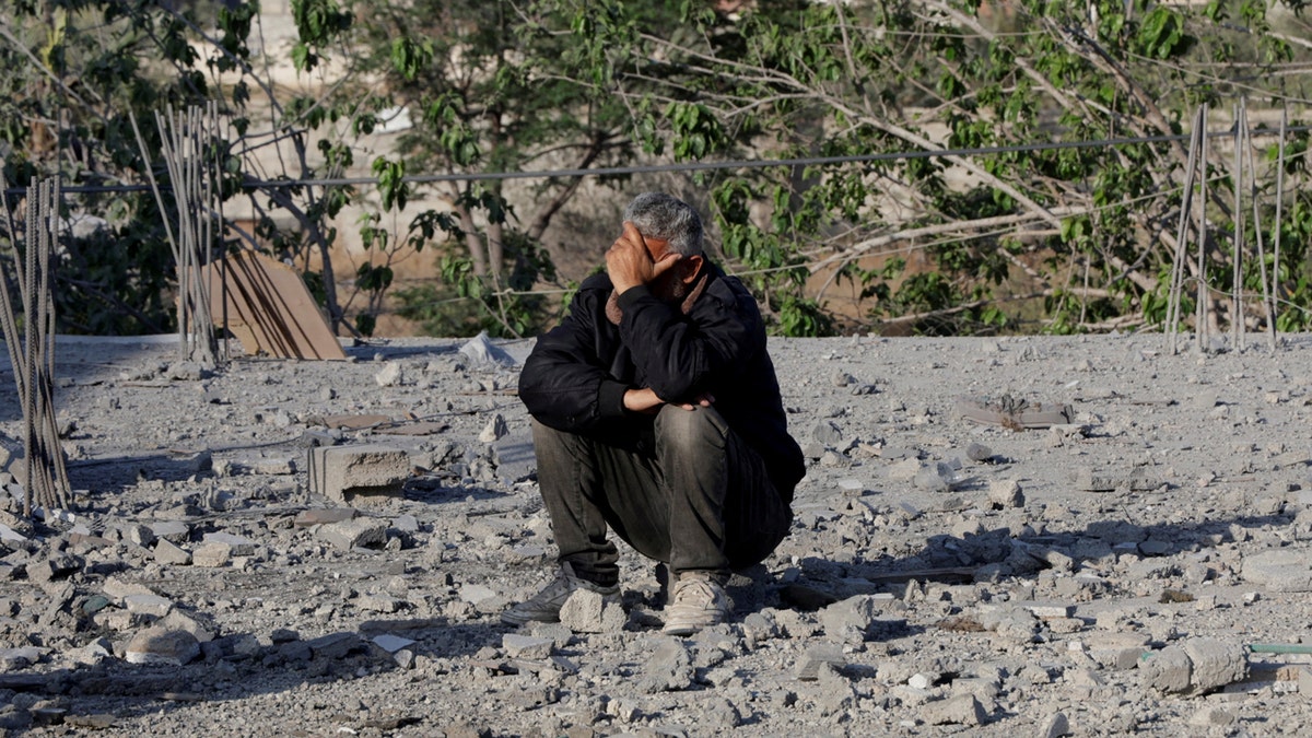 Palestinian man sitting on debris