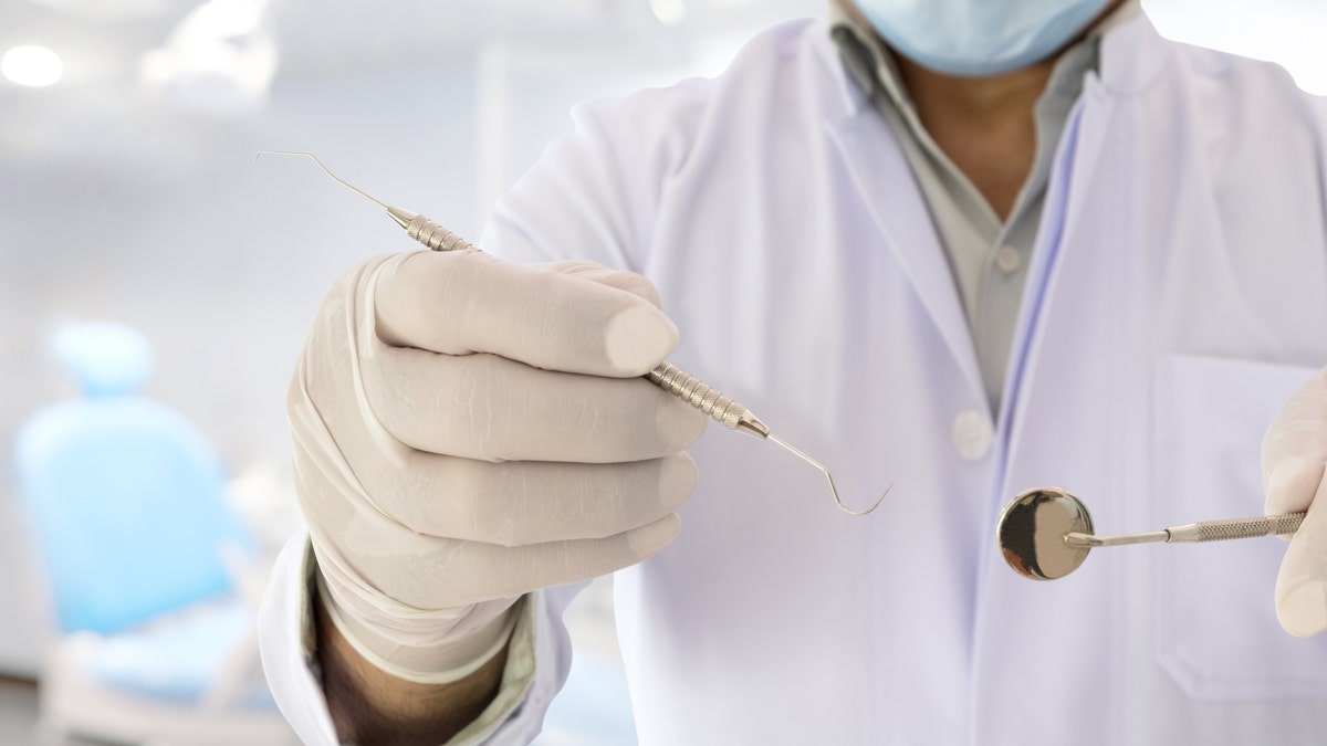 Dentist holds up tool