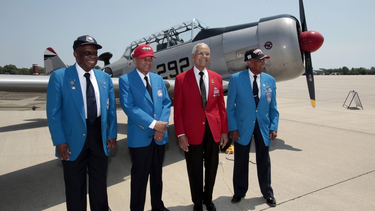 From left to right, Tuskegee Airmen pilots Lt. Colonel Washington Ross, Lt. Col. Harry Stewart, Colonel Charles McGee and Lt. Col. Alexander Jefferson stand next to a Tuskegee Army Airfield AY-6 Texan fighter plane during a ceremony to honor the airmen at Selfridge National Airbase in Harrison Township, Michigan, on June 19, 2012.