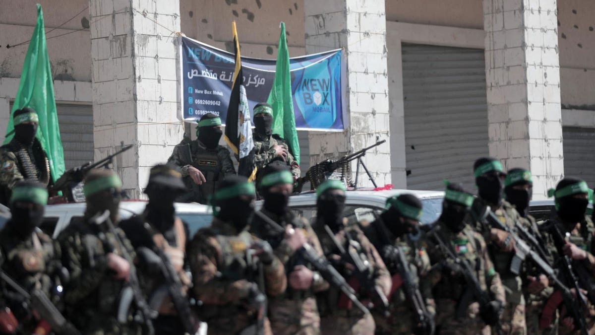Hamas terrorists watch on as four hostages are released to the Red Cross as part of a ceasefire deal between Israel and Hamas.