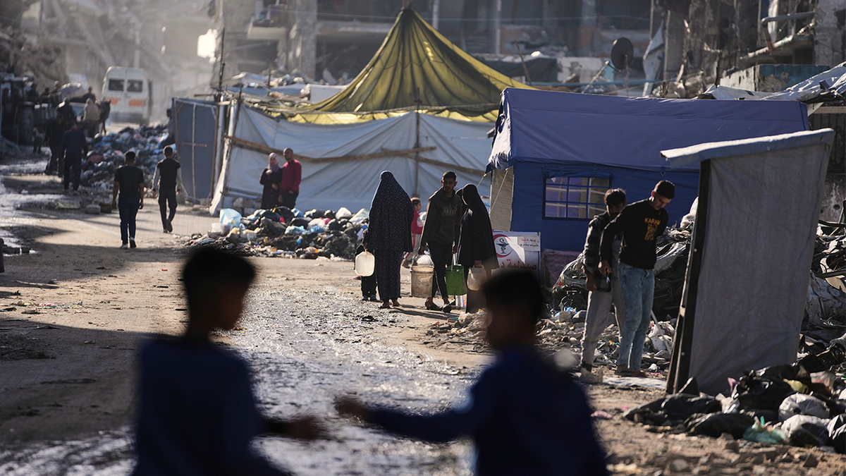 Displaced Palestinians carrying water