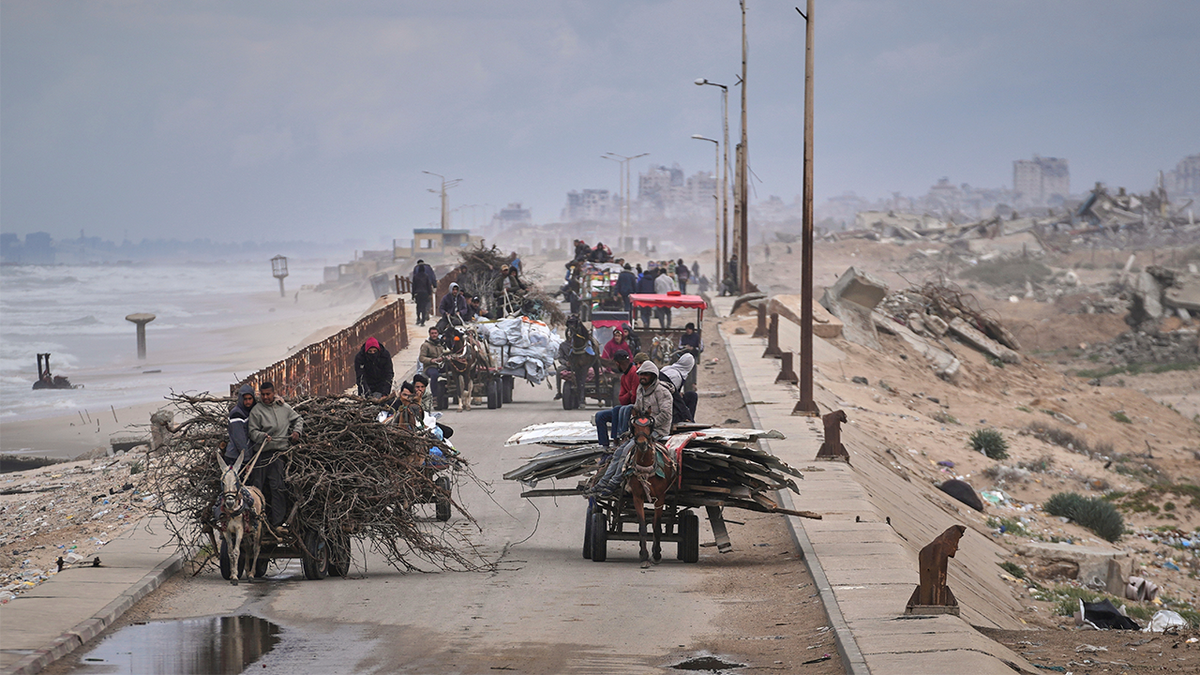 Displaced Palestinians carry their belongings