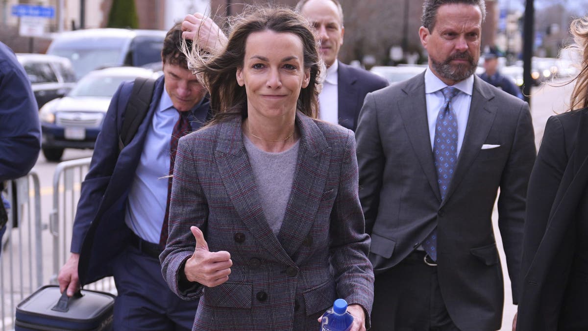 Karen Read gives a thumbs up to supporters while entering the courthouse for the first day of jury selection in her second trial