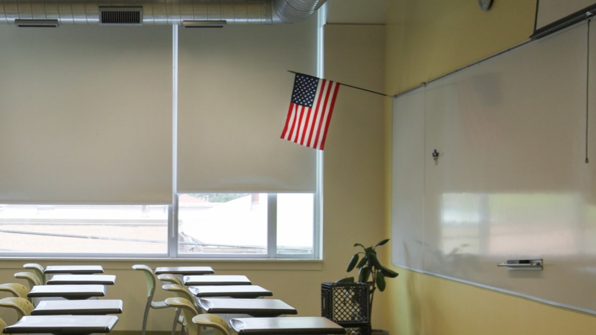 An American flag hangs in an empty classroom
