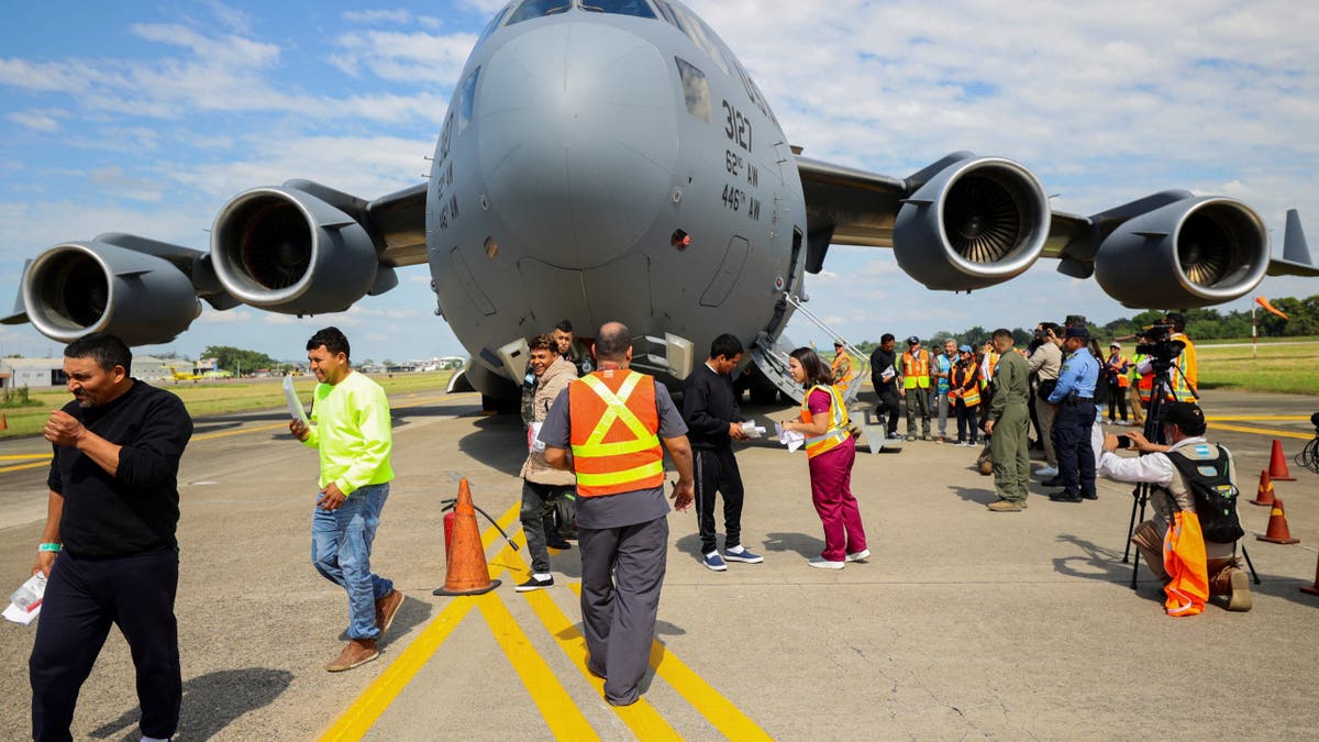 Honduran migrants ariive on tarmac