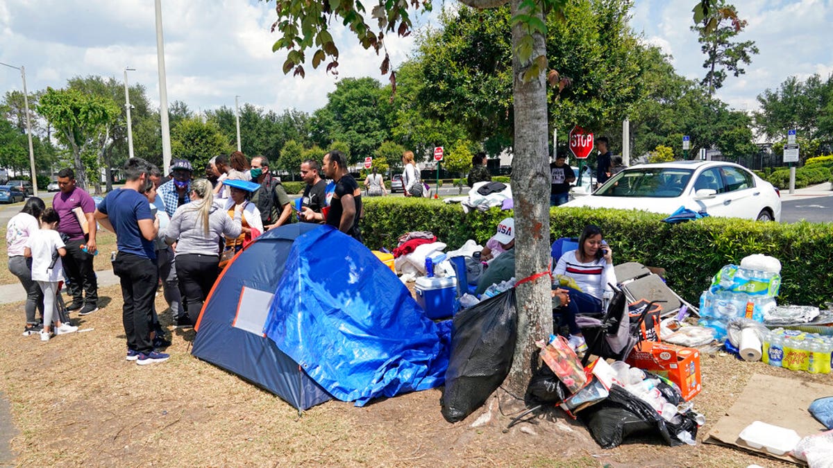 people outside, tent set up in line