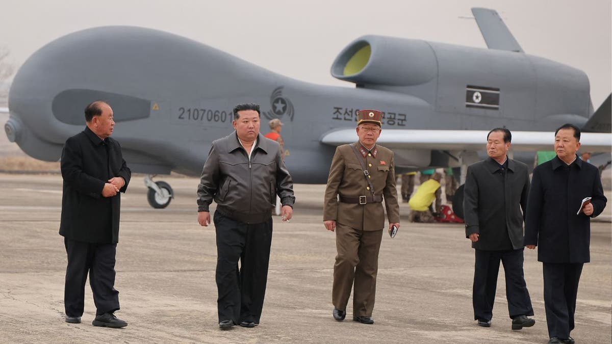North Korean leader Kim Jong Un walks alongside officials