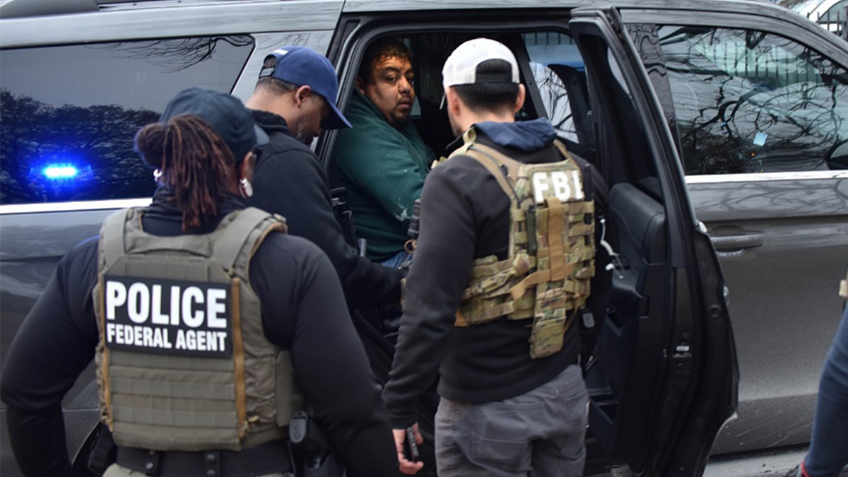 ICE agents place suspect in vehicle