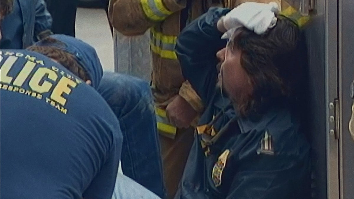 Several men in blue jumpsuits holding onto injuries.