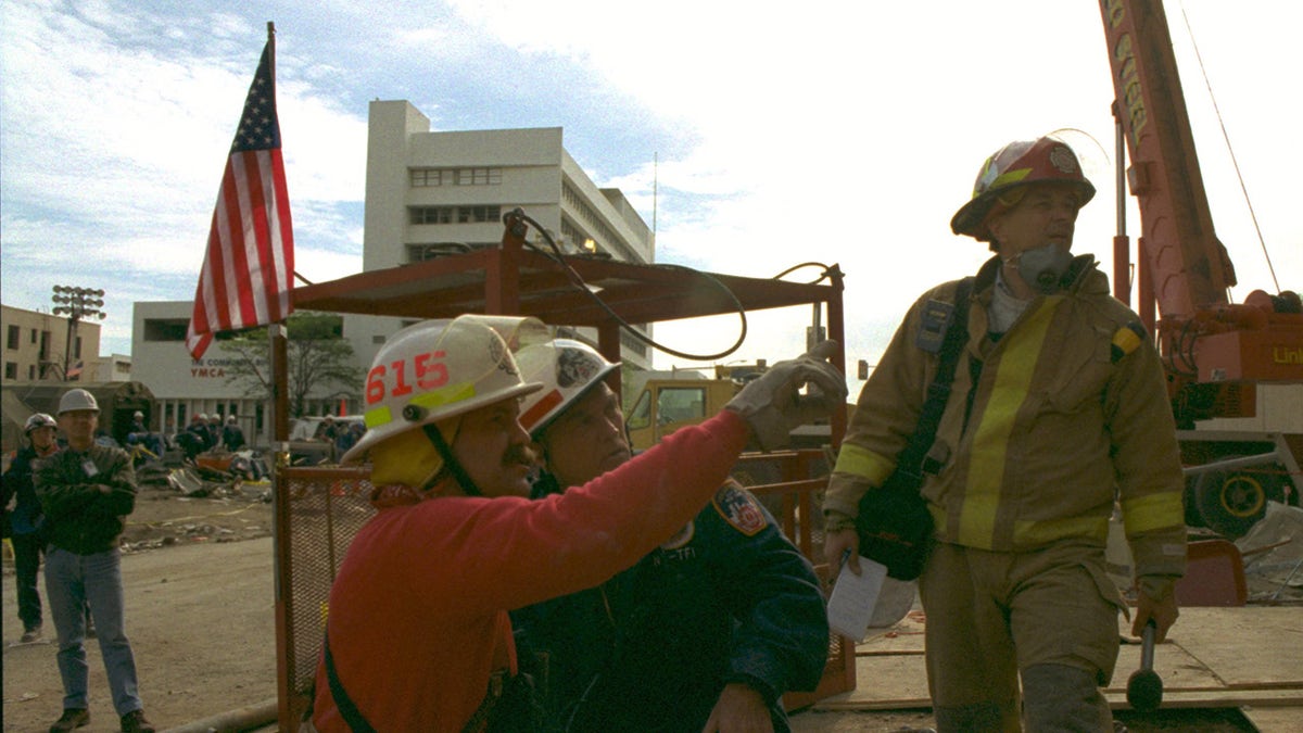 Mike Shannon with other firefighters standing outside in front of an American flag.