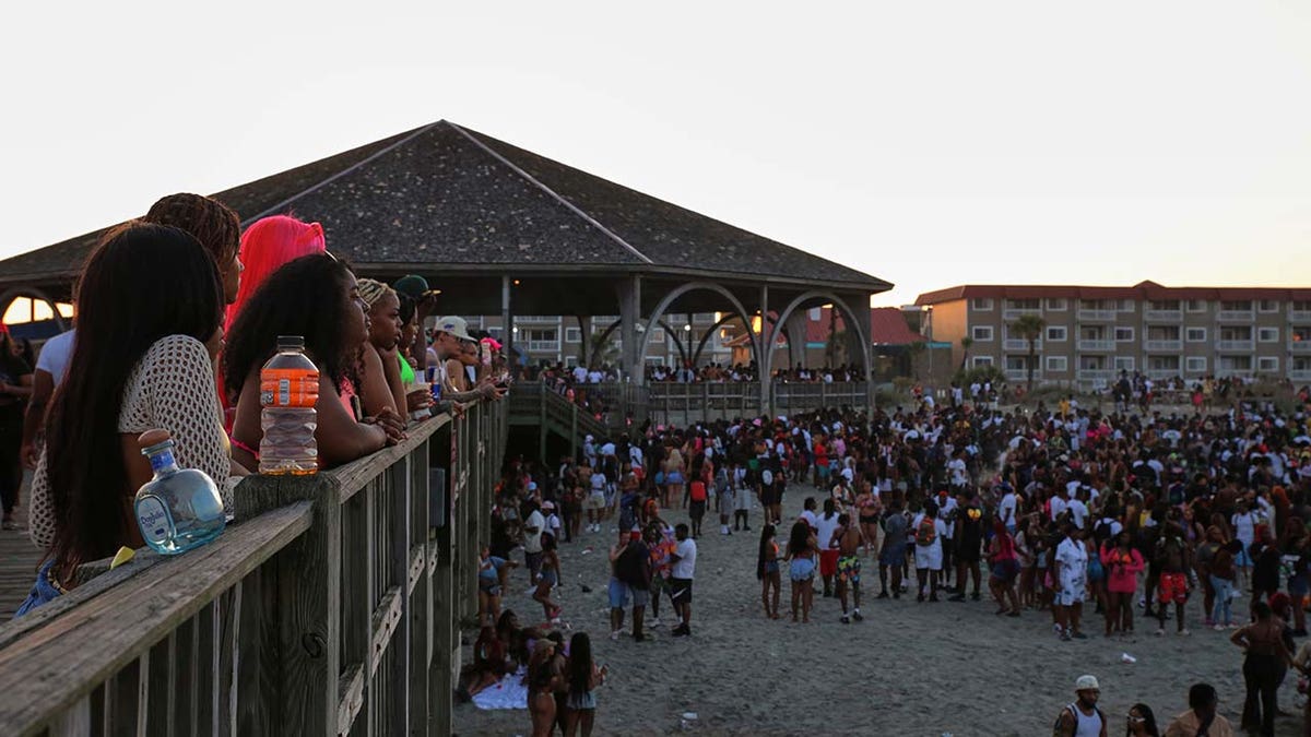 People take a break from partying to watch others from the Tybee Island Pier