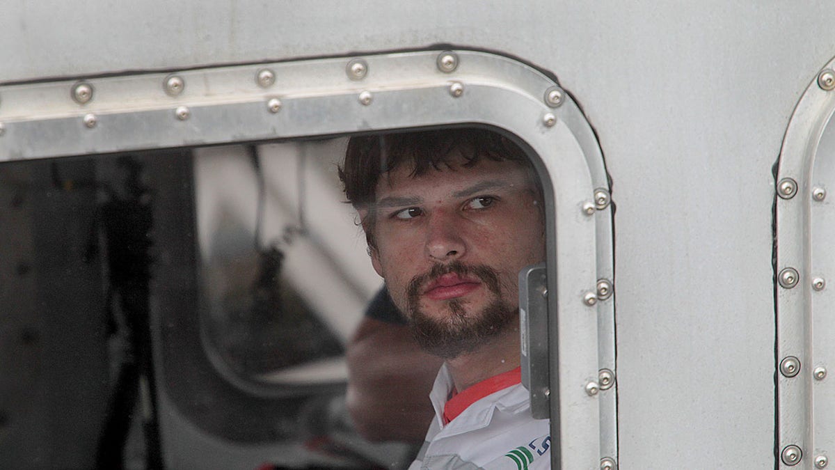 Nathan Carman looking away inside a boat.