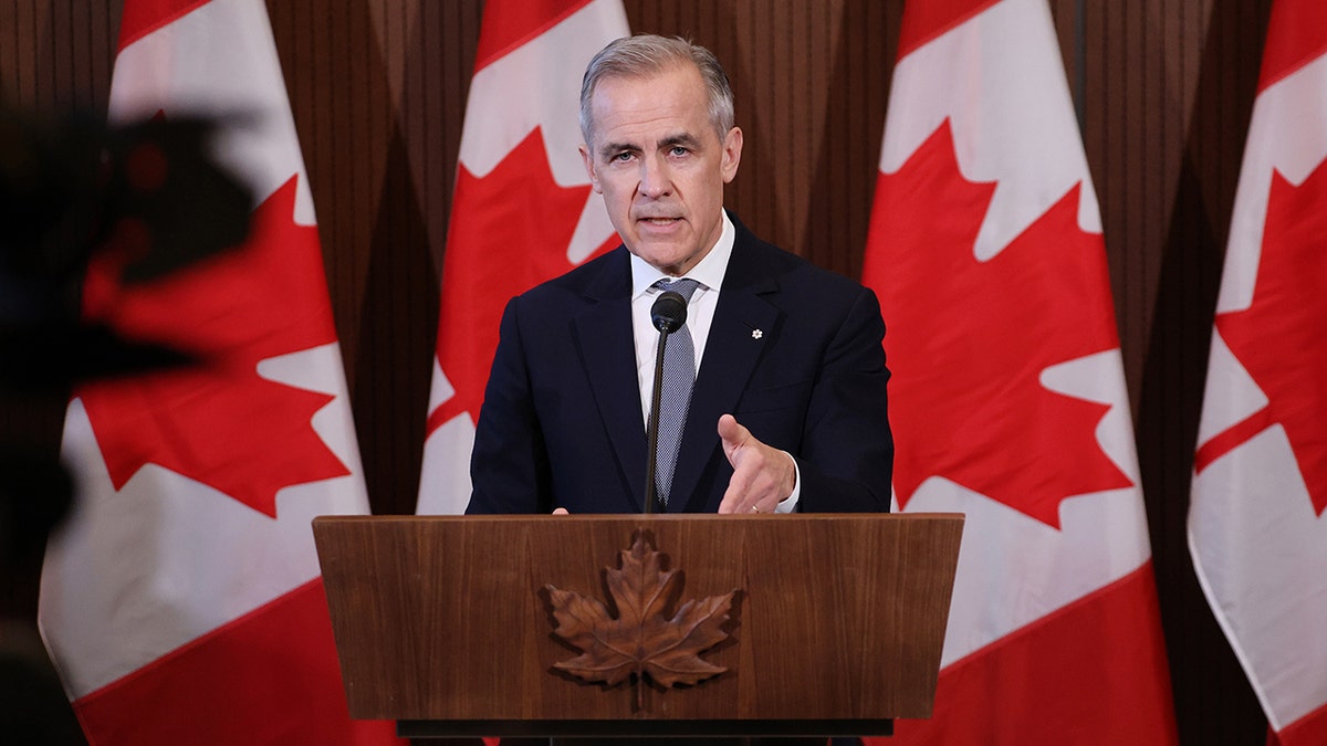 Mark Carney at podium, Canadian flags behind him