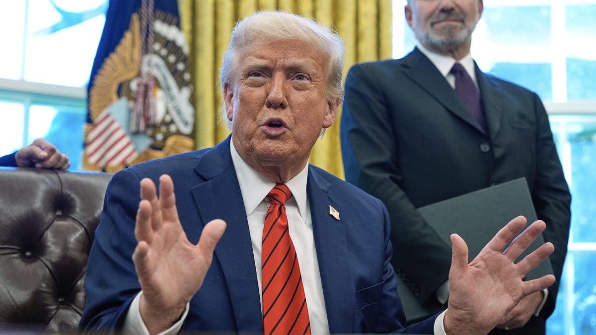 President Trump seated at desk, gesturing with hands