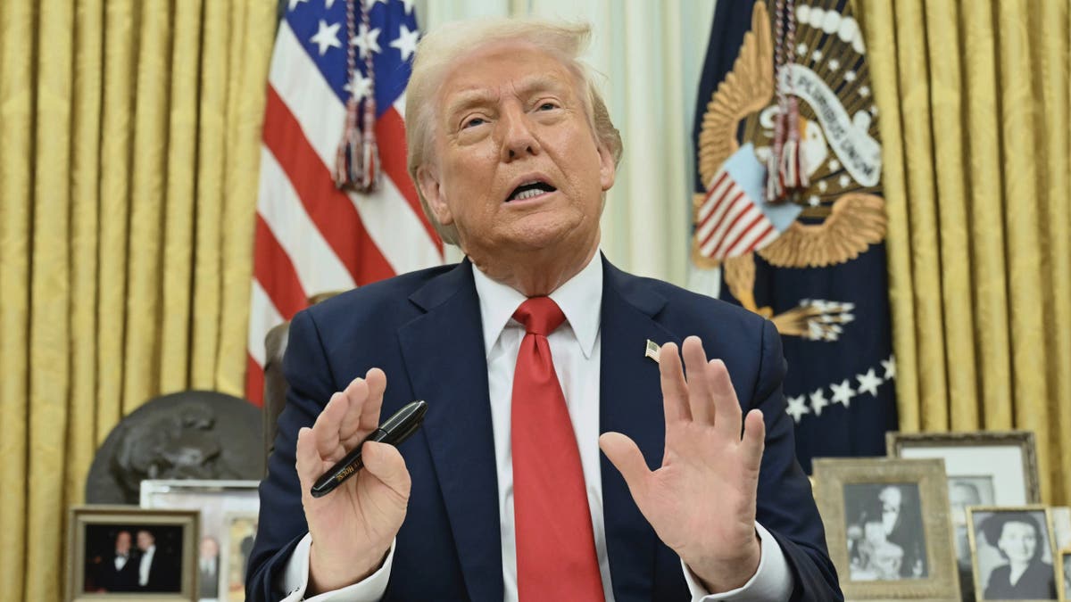 Trump holding pen, closeup shot in Oval Office