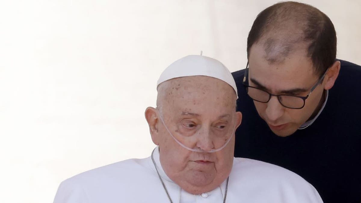 Pope Francis listens to his secretary as he appears to the faithful at the end of a Mass celebrated by Monsignor Rino Fisichella (not pictured) on the occasion of the Jubilee of Sick in St. Peter's Square at the Vatican, on April 06, 2025. (Photo by Riccardo De Luca/Anadolu via Getty Images)