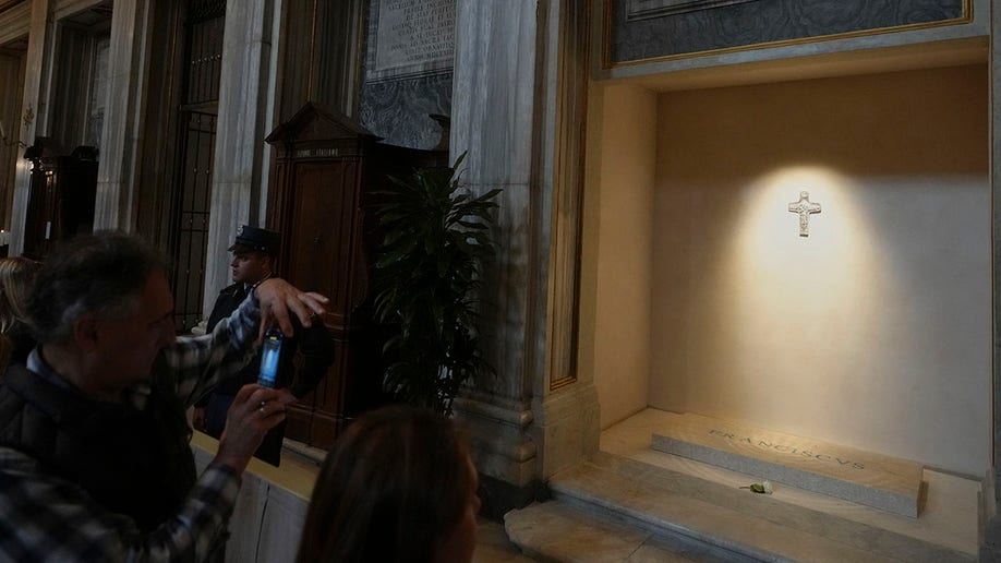 Someone snaps a photo of the tomb of Pope Francis on their cell phone