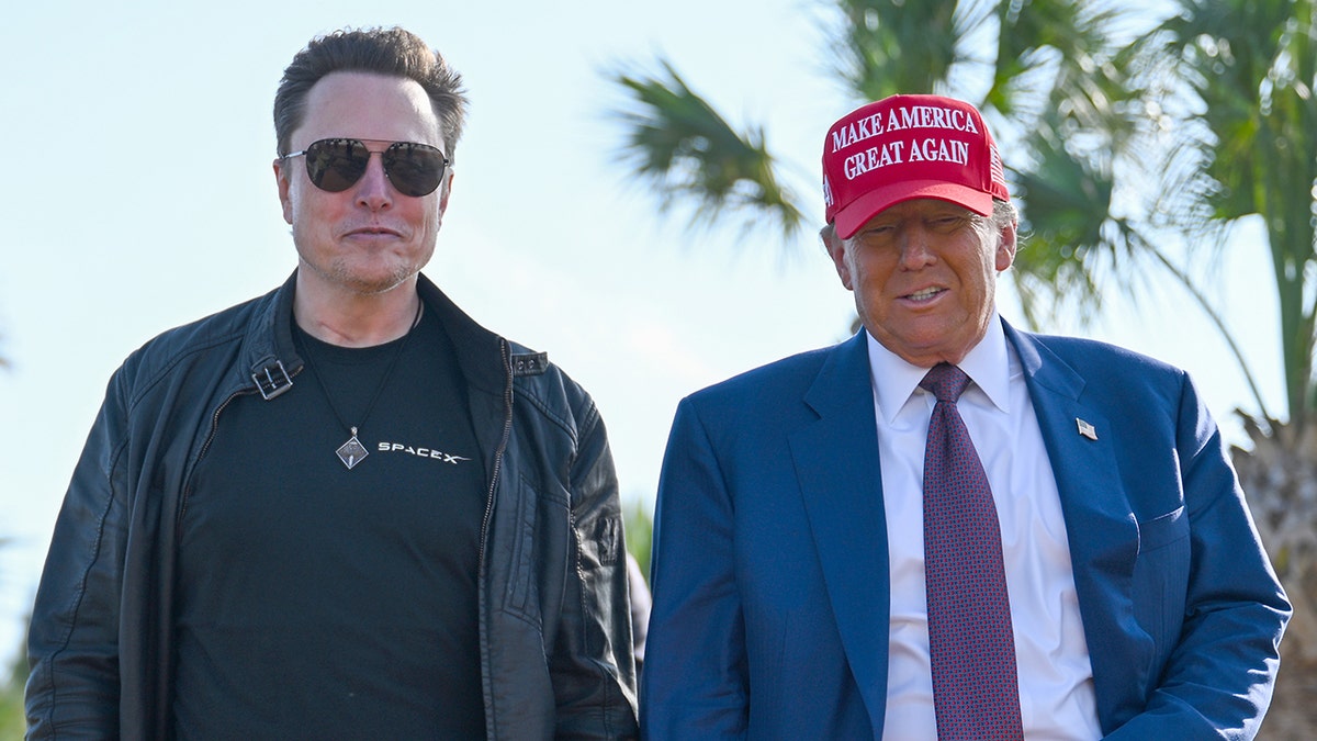 Elon Musk in dark clothing with Trump in red hat, closeup shot