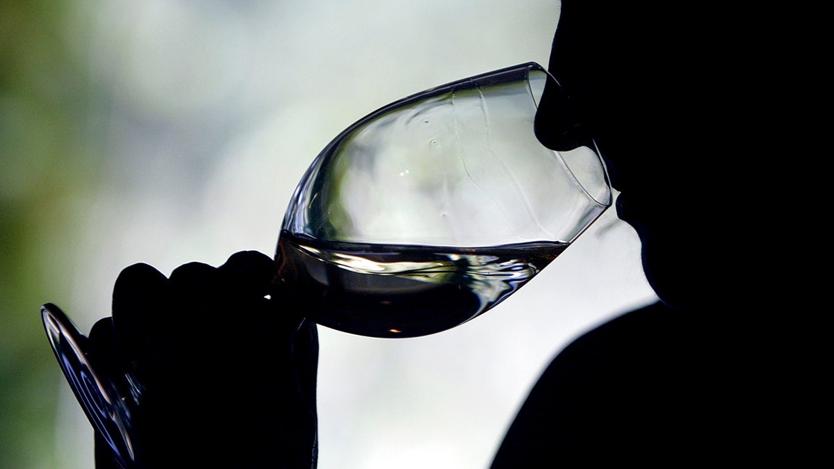 Person drinks a glass of wine