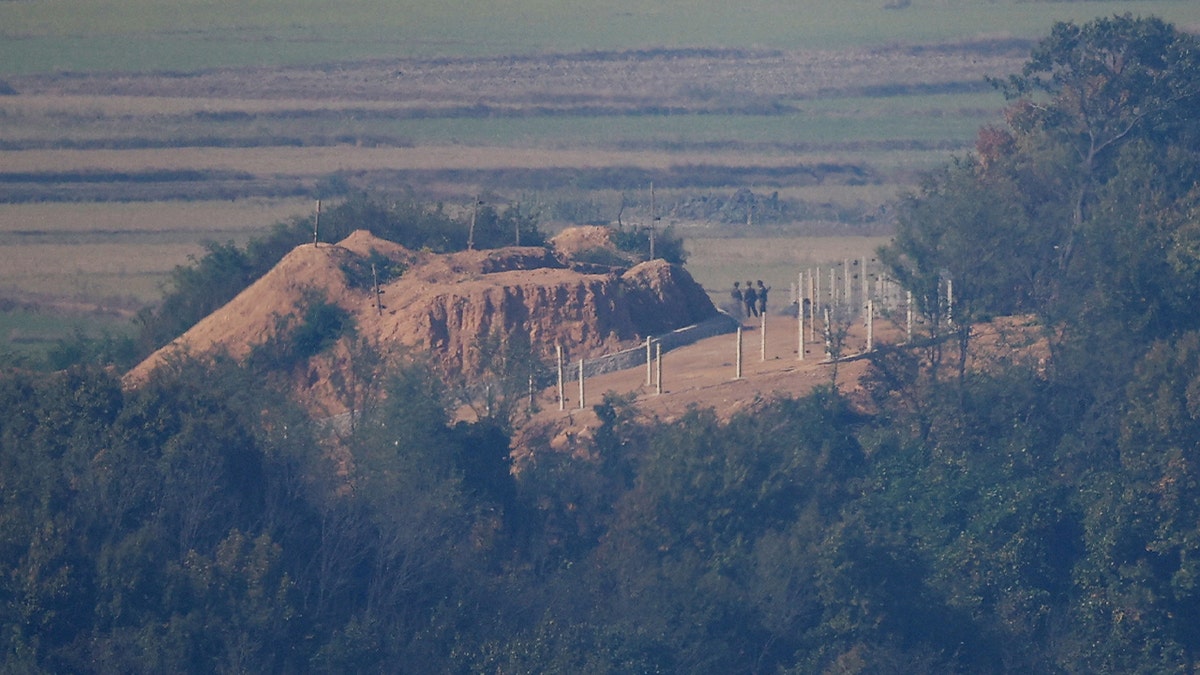 North Korean soldiers stand near a military fence at North Korea's propaganda village Kaepoong, in this picture taken from an observation near the demilitarized zone separating the two Koreas, in Paju, South Korea, on Oct. 31, 2024. 