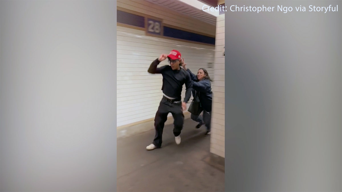 Woman leaps after man wearing MAGA hat