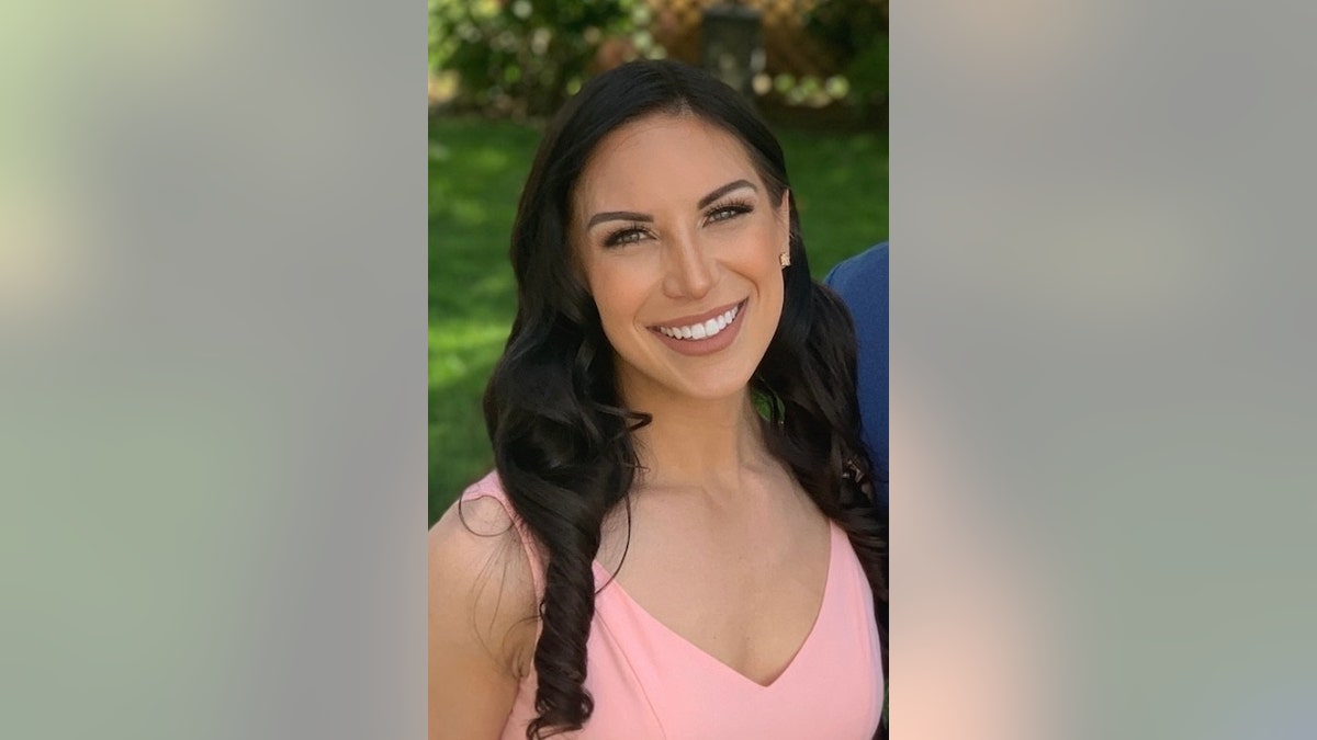 Caitlin Tracey wearing a pink dress with loosely curled brown hair