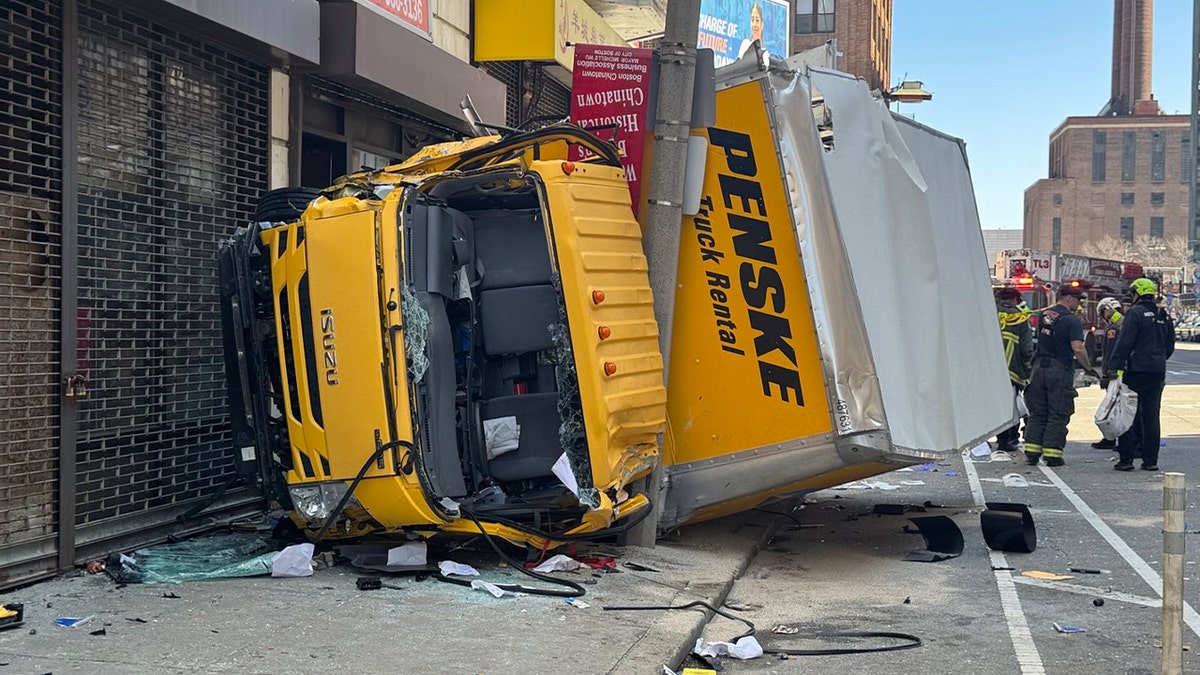A box truck crashed in Boston, striking multiple poles and becoming wedged between a pole and a building. Firefighters used extrication tools to removed the trapped driver from the cab of truck.